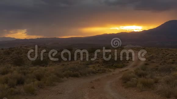 一段时间的录像显示落日的余晖在一条通往沙漠的土路上闪耀着橙色视频的预览图