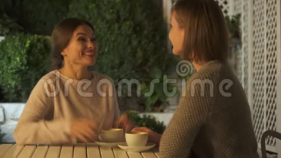 兴奋的女性和姐姐讨论即将到来的婚姻坐在露台上视频的预览图