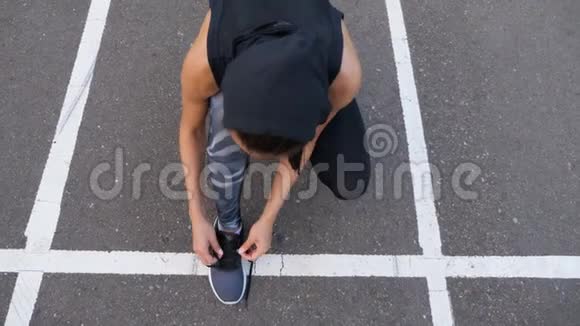 夏季傍晚慢跑时在柏油路上站着贴身妇女系鞋带视频的预览图