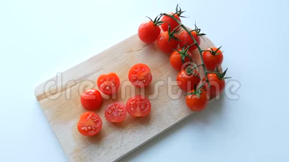 成熟的红小樱桃西红柿成串部分切在厨房板和白色背景视频的预览图