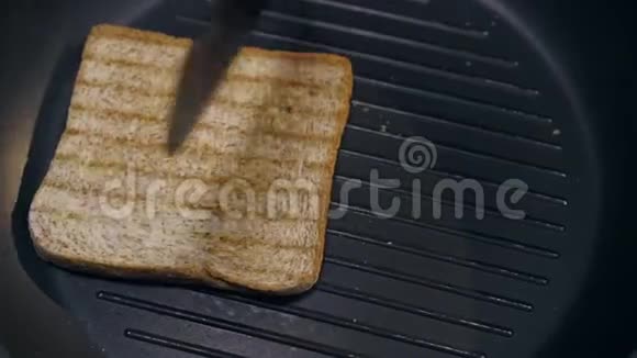厨师在热烤锅上把烤面包从一边变成另一边做三明治烤面包自制得很快视频的预览图