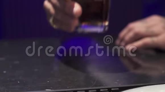 人的手把装有冰块的酒精液体放在黑桌上视频的预览图