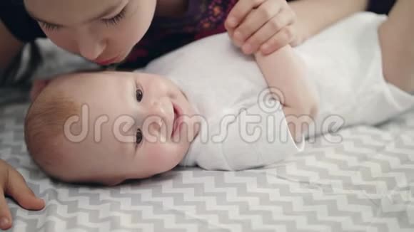 姐妹爱情观念婴儿从妹妹亲吻中微笑可爱的童年视频的预览图