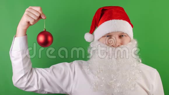 像圣诞老人一样的人带着红色圣诞球玩具2019年新年绿色Chroma键循环电影视频的预览图