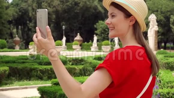 女人在公园里慢动作使用手机游客通过VillaBorghese应用程序进行视频聊天视频的预览图
