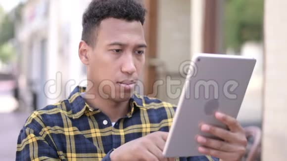 非洲青年男子应对平板电脑损失室外视频的预览图