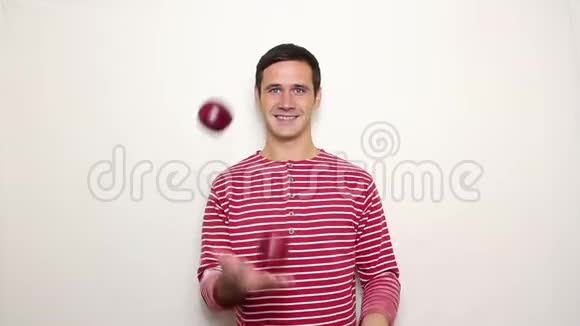 年轻的帅哥穿着一件条纹毛衣笑得很宽手里拿着三个红苹果视频的预览图