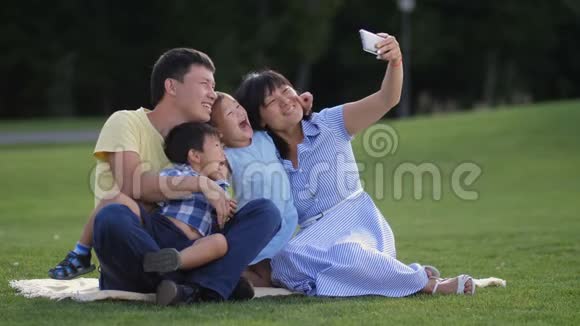 欢乐的亚洲家庭和孩子们在公园自拍视频的预览图