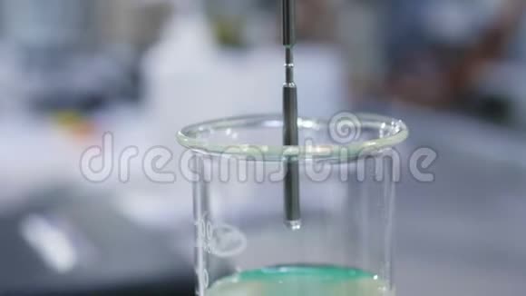实验室烧杯中放入透明黏液的近景金属管视频的预览图