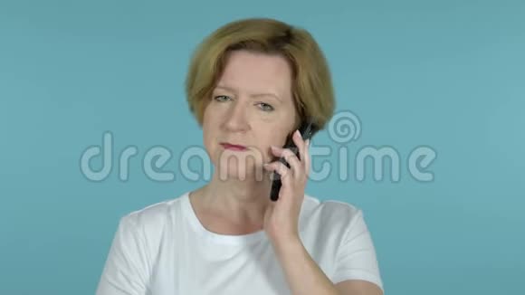 蓝底智能手机上说话的老女人视频的预览图