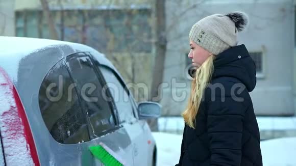 一个年轻的女孩刷她的雪车冬天的早晨视频的预览图