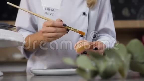 女人的双手用金色的飞溅装饰马卡龙视频的预览图