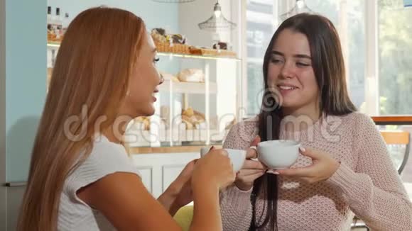 快乐的女性朋友在一起喝咖啡时微笑着对着镜头视频的预览图