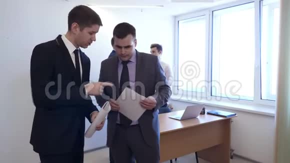 商人和他的同事站在一起讨论文件视频的预览图
