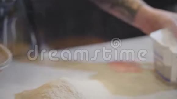 有纹身的厨师手通过一个筛子把面粉播种现代餐厅烘焙面包的过程厨师工作视频的预览图