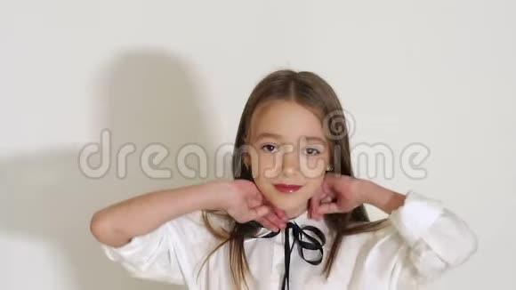 一位留着长发的小女孩在一间白色墙壁的房间里摆姿势视频的预览图