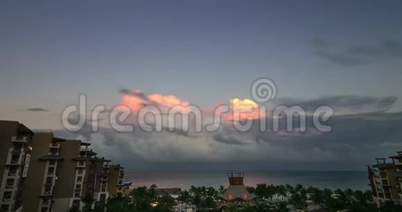 一个巨大的积雨云在顶部被夕阳照亮在墨西哥坎昆附近的热带水域视频的预览图