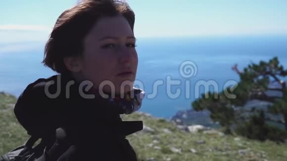 年轻漂亮的女孩走在山顶的海面上视频的预览图
