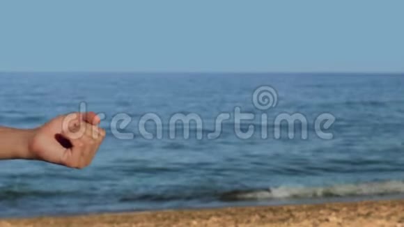 男性手在海滩上拿着一个概念全息图与文本参考视频的预览图