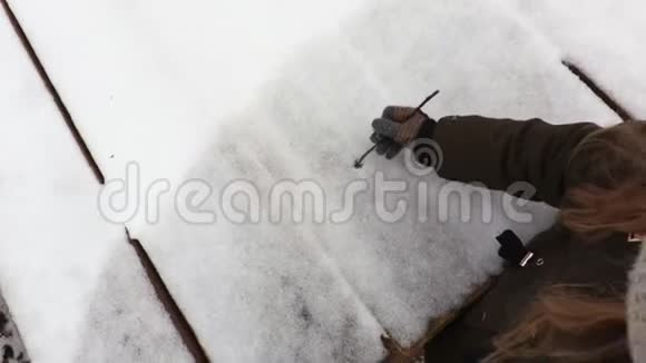 小女孩在雪地上画着心形视频的预览图