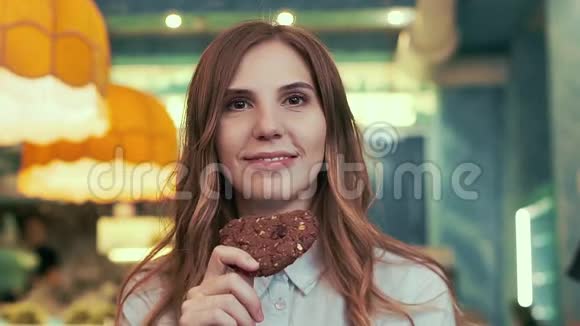 咖啡馆里的一个美女手里拿着一块饼干微笑着视频的预览图