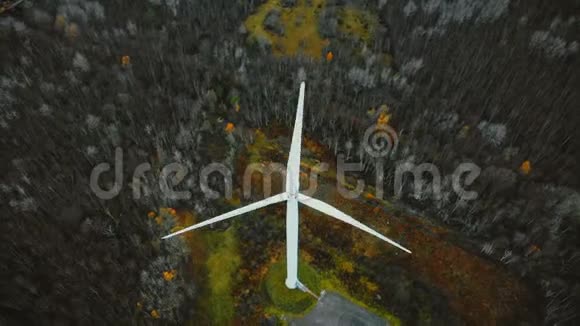 俯视无人机飞越工作风车在冬季森林未来替代可再生生态友好能源概念视频的预览图