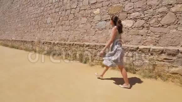 西班牙巴塞罗那旅游妇女沿着城堡的高墙散步看石头视频的预览图
