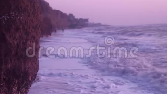 大浪带着白色的海泡在沙滩上打着湿沙粘土岩在蓝天上视频的预览图