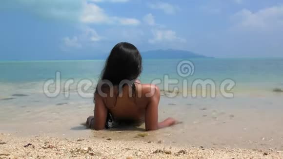 小女孩在海滩上晒日光浴视频的预览图