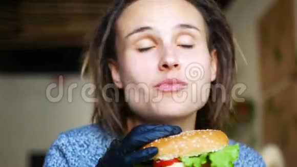 年轻的高加索少女正在吃一个多汁的素食汉堡和跳舞视频的预览图