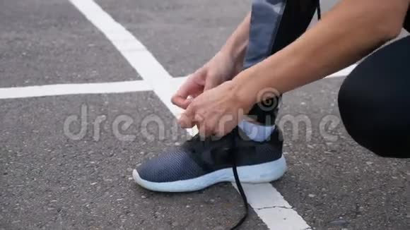 女孩跑步者系鞋带以便在公园的路上慢跑视频的预览图