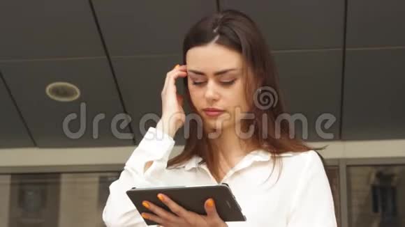 大风天年轻的女商人用平板电脑视频的预览图