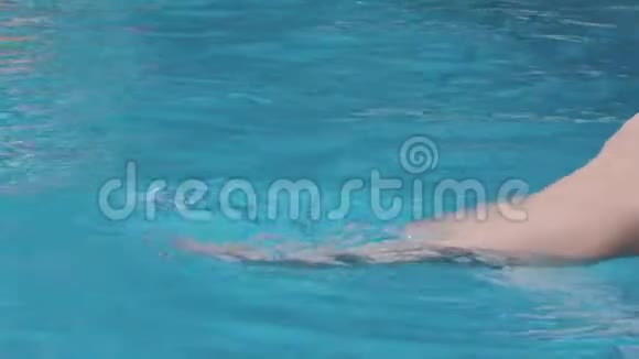 特写慢镜头的女性腿溅在游泳池小女孩腿在清澈的水池里移动溅起水花视频的预览图