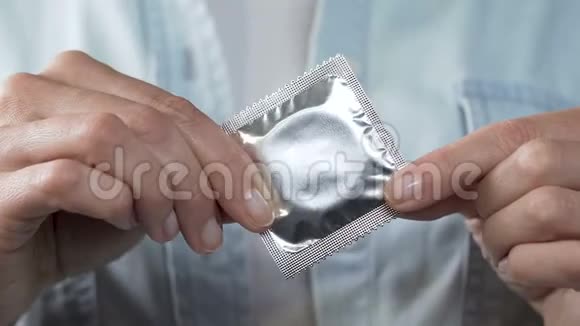 持有密封避孕套性传播疾病保护的女性手指视频的预览图