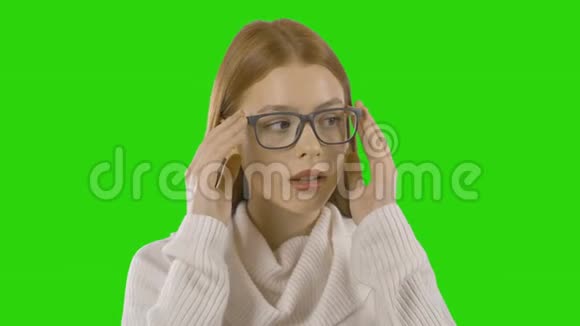 一个漂亮的红发女孩戴着时髦的眼镜戴着一个孤立的绿色屏幕视频的预览图