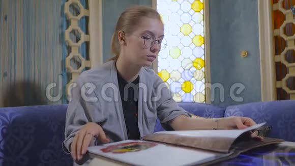 戴眼镜的年轻女子正在一家亚洲餐馆翻菜单视频的预览图
