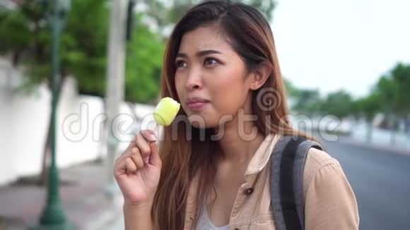 在户外场景中一个年轻的女人用冰棒冰淇淋竖起大拇指视频的预览图