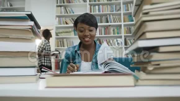 微笑非洲女学生学习在现代图书馆看书视频的预览图
