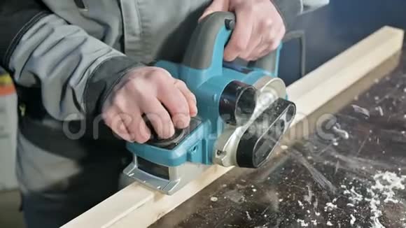 木工在家庭车间用电平面工作的手的特写整理木制部件视频的预览图
