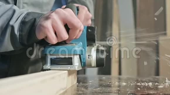木工在家庭车间用电平面工作的手的特写整理木制部件视频的预览图
