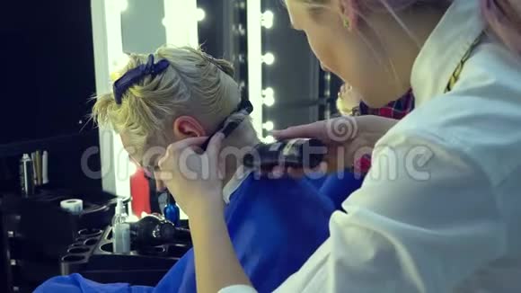 美容院理发店发型师理发师给年轻女孩理发造型师用电动剃须刀和梳子视频的预览图