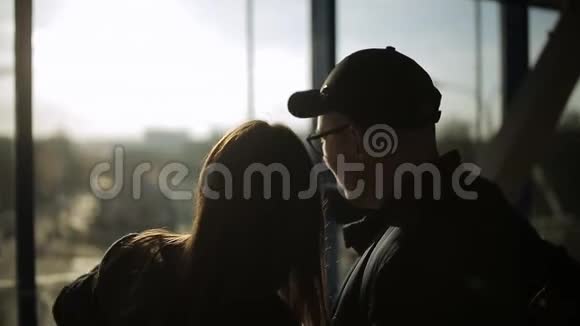 机场游客剪影男孩和女孩站在窗户前兴高采烈地说话妇女视频的预览图
