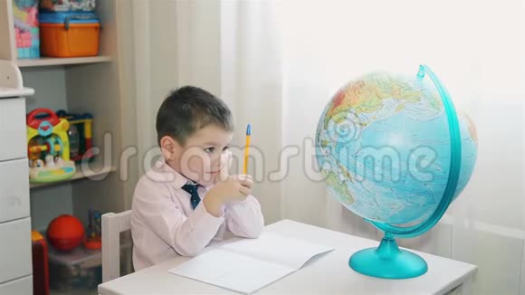 孩子研究地球并在笔记本上写笔记视频的预览图