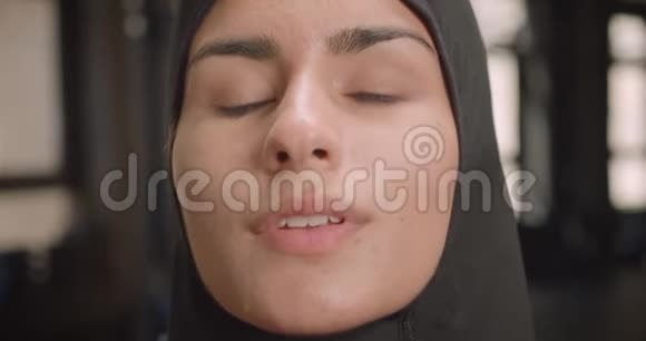 年轻成功运动的穆斯林女性在健身房里坚定地看着摄像机的特写镜头视频的预览图