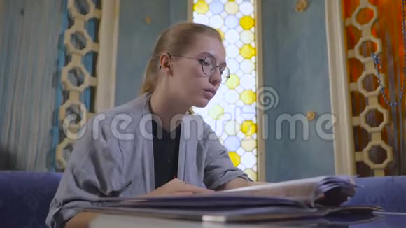 戴眼镜的年轻女子正在一家亚洲餐馆翻菜单视频的预览图