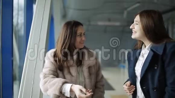一男两女在机场大厅窗口等候办理登机手续视频的预览图