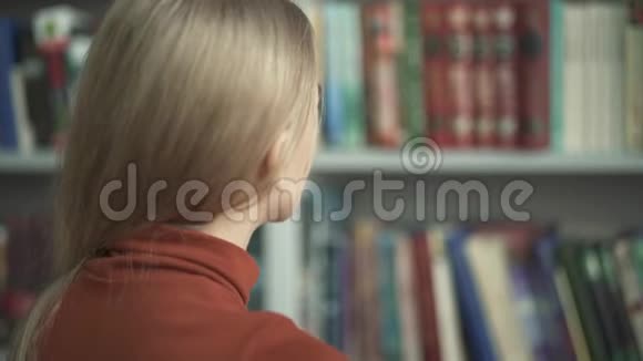 这位女作家正在挑选哪本书进图书馆视频的预览图