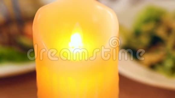 节日桌上的黄色LED蜡烛特写视频的预览图