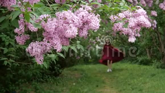 穿着宽松衣服的瘦小女孩欢快地穿过花园视频的预览图