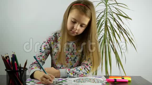 书桌前的一个女孩在笔记本上上色视频的预览图